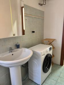 a bathroom with a washing machine next to a sink at Trilocale a 100 m dal mare in Imperia +14 photos