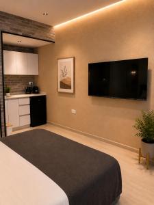 a bedroom with a large bed and a flat screen tv at Dizengoff Square Garden - by BAR COLLECTION in Tel Aviv