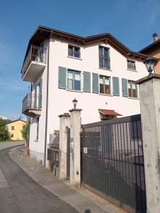 a white building with a gate and a fence at Appartamento Bonita Vista in Colico