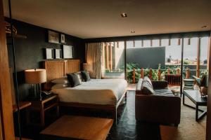 a bedroom with a bed and a couch and a window at Cinco Rodavento in Valle de Bravo +90 photos