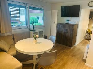 a living room with a table and a couch at Garden Lodge Obervellach in Obervellach