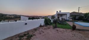 a villa with a swimming pool and a white wall at Villa Mares in Casas Novas de Marés