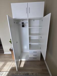 a white closet with white drawers and shelves at Ülejõe Apartment with Free Parking in Pärnu