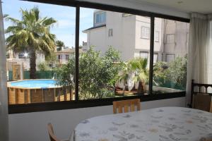 uma sala de jantar com uma mesa e vista para uma piscina em Villa Es Tamarells Blue em Can Picafort