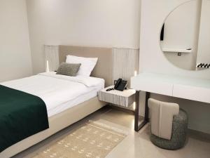 a bedroom with a bed and a sink and a mirror at Hotel Maamoun in Gafsa +33 photos