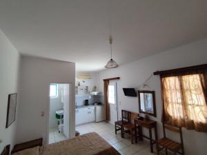 a living room with a table and a kitchen at Areti studios in Vathi