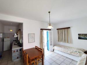 a bedroom with a bed and a table and a kitchen at Areti studios in Vathi