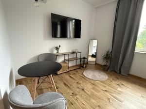 a living room with two chairs and a tv on the wall at Zacisze in Karczmiska
