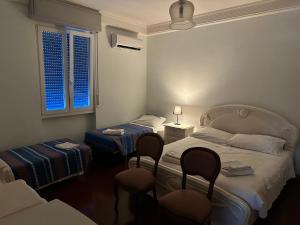 ein Hotelzimmer mit zwei Betten und zwei Stühlen in der Unterkunft Mavipagi 2 in Verona