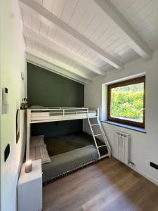 a bedroom with a bunk bed with a window at Casa Amor Iseo Lake in Riva di Solto