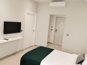 a bedroom with a bed and a flat screen tv at Hotel Maamoun in Gafsa