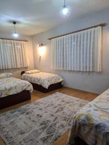 a bedroom with two beds and a rug at Simal Apart Ev in Ayder Yaylasi