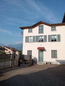 a white house with a gate and a fence at Appartamento Bonita Vista in Colico