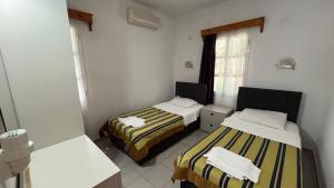 a room with two beds and a window at Ege Apartments in Yalıkavak +37 photos