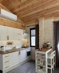 a kitchen with white cabinets and a wooden ceiling at Villa Del Rio Karadeniz River Palace Ayder in Çamlıhemşin