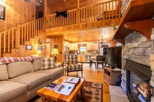 a living room with a couch and a stone fireplace at A Bears Hill in Boone