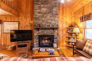 a living room with a fireplace and a flat screen tv at A Bears Hill in Boone