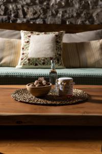a table with a bowl of food and a bottle of alcohol at PETRASTERO Mountain Retreat-Agrafa Evrytania Greece in Vérnikon