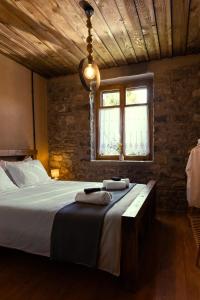 a bedroom with a bed and a window at PETRASTERO Mountain Retreat-Agrafa Evrytania Greece in Vérnikon +56 photos