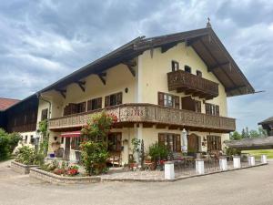 a large building with a balcony on top of it at Weissenhof | Chiemgau Karte in Rottau