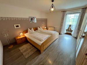 a bedroom with a large bed and a large window at Weissenhof | Chiemgau Karte in Rottau