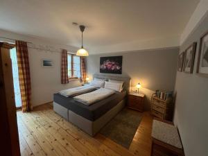 a bedroom with a bed and a pendant light at Weissenhof | Chiemgau Karte in Rottau +6 photos