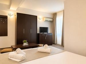 a hotel room with a bed with two towels at Casa Mario in Eforie Nord