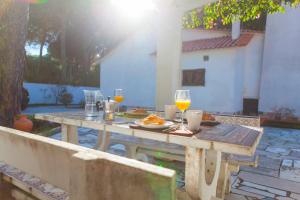 a wooden table with glasses of wine and food on it at Ocean, Pines and Mountain - Renovated February 2025 - AC in Sintra