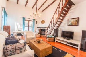 a living room with a couch and a tv at Ocean, Pines and Mountain in Sintra