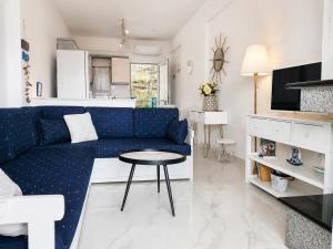 a living room with a blue couch and a table at Siviri Sea & Forest-Cozy Apartment with Garden & Nature Views in Siviri