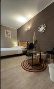 a bedroom with a bed and a table and a chair at GOOD NIGHT HÔTEL By L'excess in Vierzon