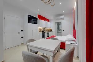 a white room with a bed and a table and chairs at Swimming Pool - Marko Studios Berat in Berat