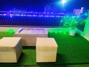 a patio with two benches on the grass at night at MosesVilla in Jabalpur