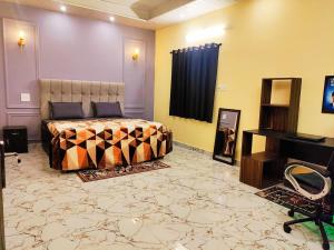 a bedroom with a bed and a desk and a piano at MosesVilla in Jabalpur