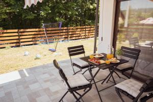 a table and chairs with a plate of food on a patio at Riverside Home Laura in Karlovac