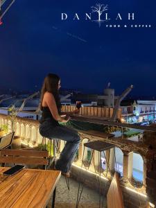 a woman sitting at a table with a glass of wine at Hotel Portal & Suites in Ciudad Hidalgo