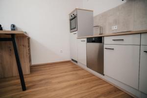 a kitchen with white appliances and a wooden floor at Fewo-Welz in Bad Kissingen +16 photos