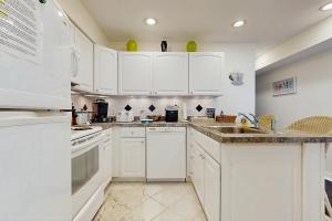a white kitchen with white cabinets and a sink at Mallard Lakes - 38082 Mockingbird Ln in Selbyville