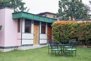 a table and chairs in front of a small house at Morika Hotel in Mbarara +1 photo