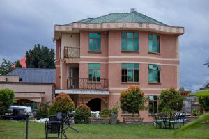a brown building with a green roof at Morika Hotel in Mbarara