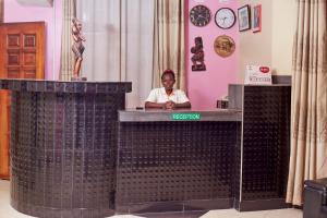 a woman is sitting at a reception desk at Morika Hotel in Mbarara