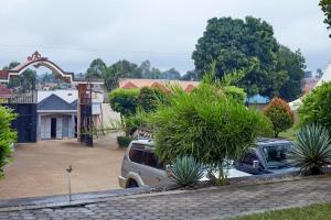 a van parked in a driveway in front of a house at Morika Hotel in Mbarara