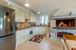 a kitchen with a fireplace in the middle of it at Trasorka House in Veli Lošinj +23 photos