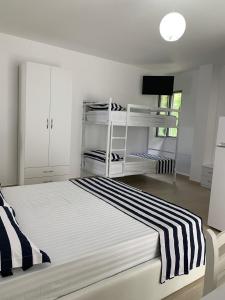 a white bedroom with a bed with a black and white stripes at Vila Kalluci in Borsh