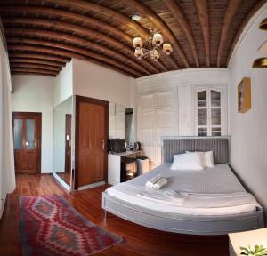 a bedroom with a large bed with a wooden ceiling at Gaziayintap Konağı in Şahinbey