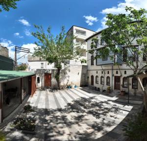 a building with a tree in the middle of a street at Gaziayintap Konağı in Şahinbey