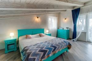 a bedroom with a blue bed and two blue night stands at Trasorka House in Veli Lošinj
