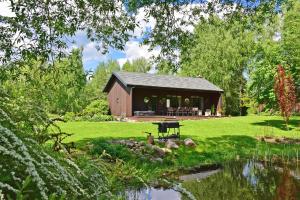a barn with a picnic table next to a pond at Pramogų namelis in Naručionys