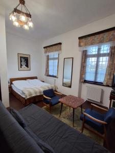 a bedroom with a bed and a couch and a table at Pałac Stanica in Przeworno