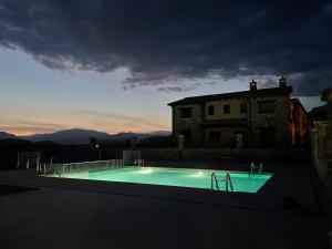 a swimming pool in front of a house at night at Casas Pirineo, Ainsa in Aínsa
